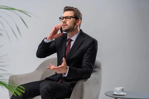 Homem Negócios Irritado Sentado Poltrona Falando Por Smartphone — Fotografia de Stock