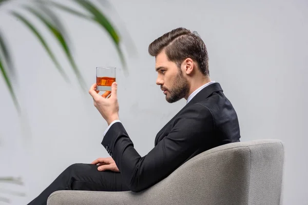 Geschäftsmann Sitzt Sessel Und Schaut Auf Ein Glas Whiskey — Stockfoto