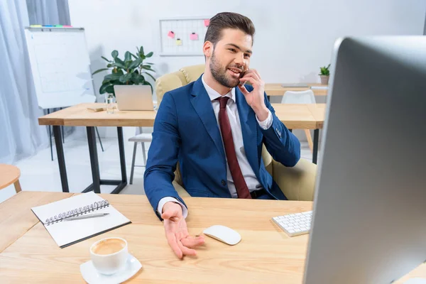 Smiling Businessman Talking Smartphone Looking Computer — Φωτογραφία Αρχείου