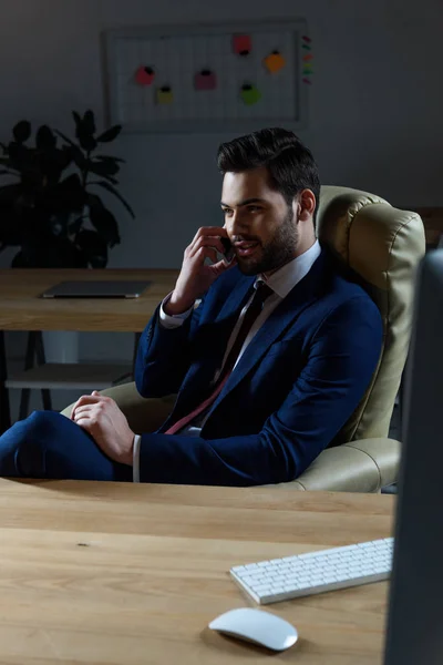 暗いオフィスでスマート フォンで話すビジネスマン — ストック写真