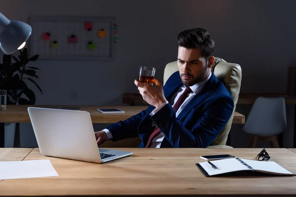 Hombre Negocios Serio Sentado Ordenador Portátil Con Vaso Whisky — Foto de stock gratis
