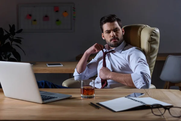 Müder Geschäftsmann Lockert Krawatte Und Sitzt Mit Einem Glas Whisky — Stockfoto