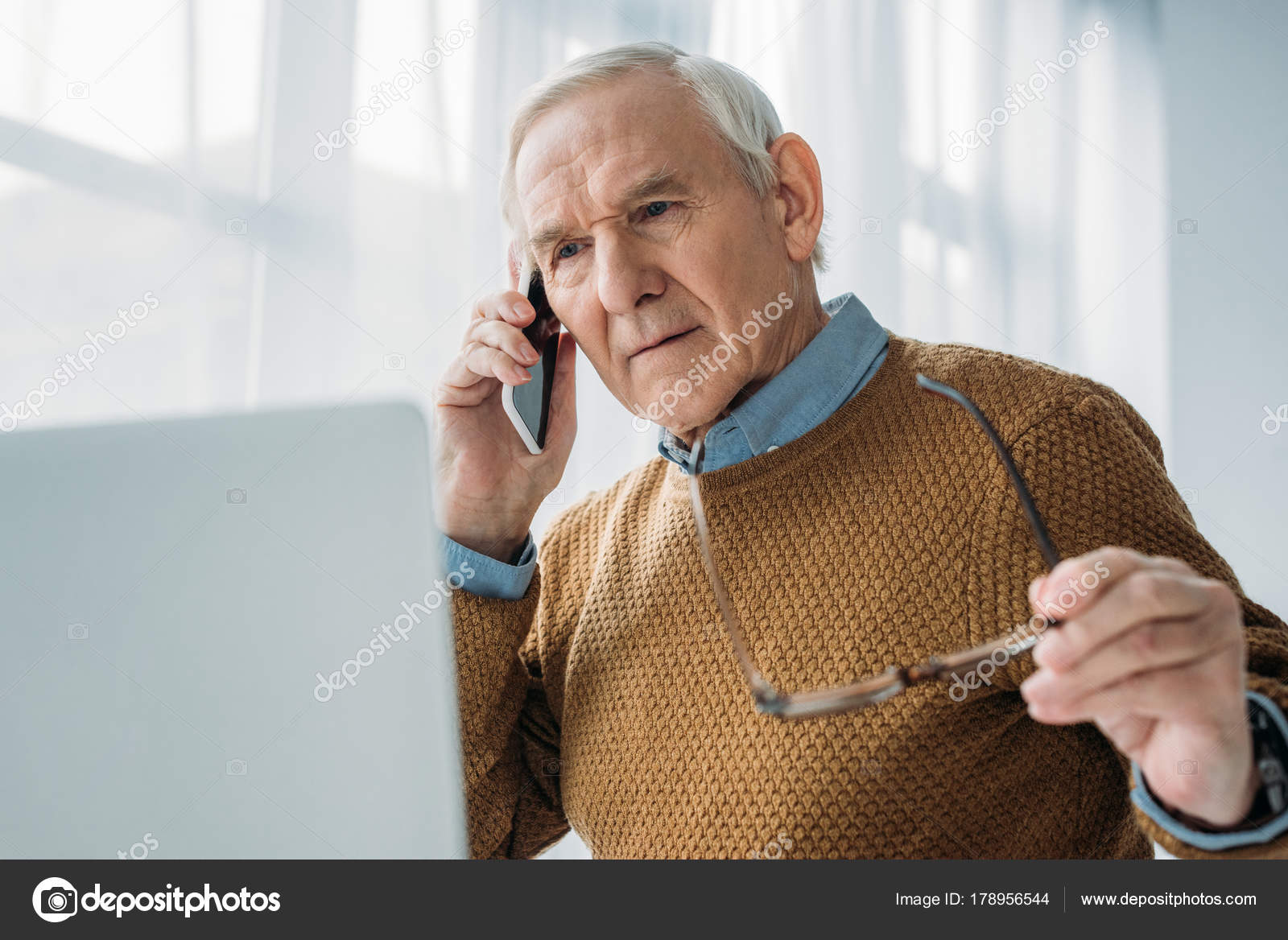 Senior busy man working in office and making phone call