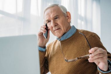 Ofiste çalışan ve telefon görüşmesi kıdemli meşgul adam