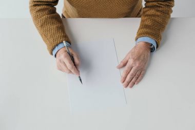 Close-up view of senior man writing on blank paper clipart