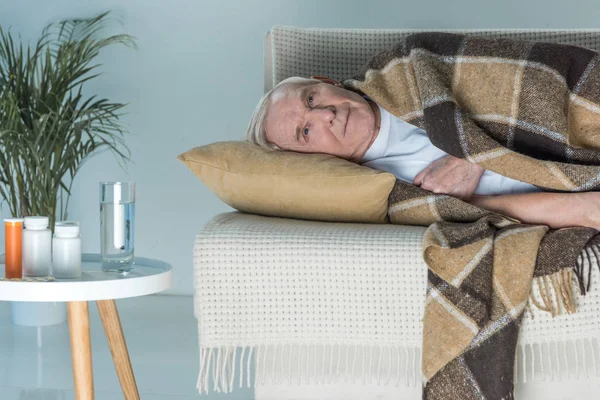 Senior Kranker Mann Plaid Liegt Auf Sofa Zimmer Mit Medikamenten Stockbild