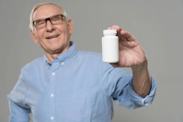 Senior Confident Man Holds White Bottle Pills Isolated Gray Background — Stock Photo, Image