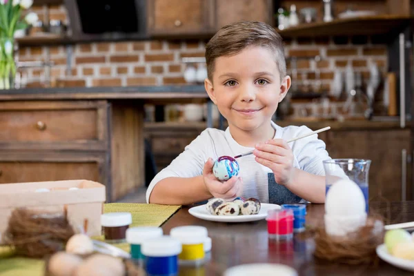 Хлопчик малює пасхальне яйце — стокове фото