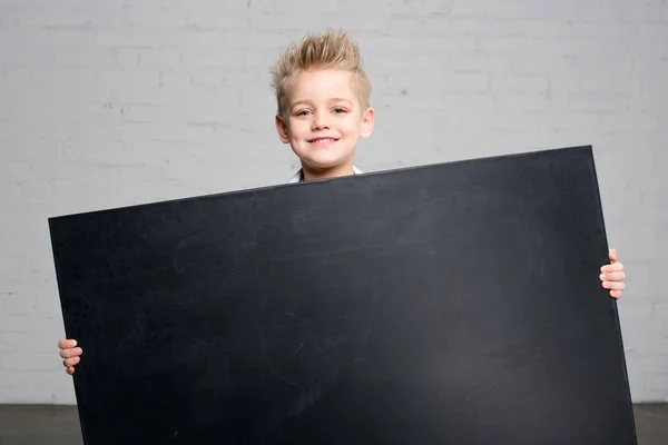 Boy holding blackboard — Stock Photo