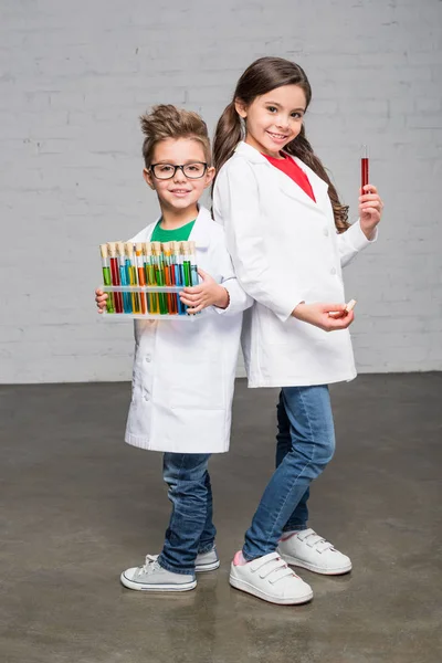 Niños sosteniendo tubos de ensayo - foto de stock