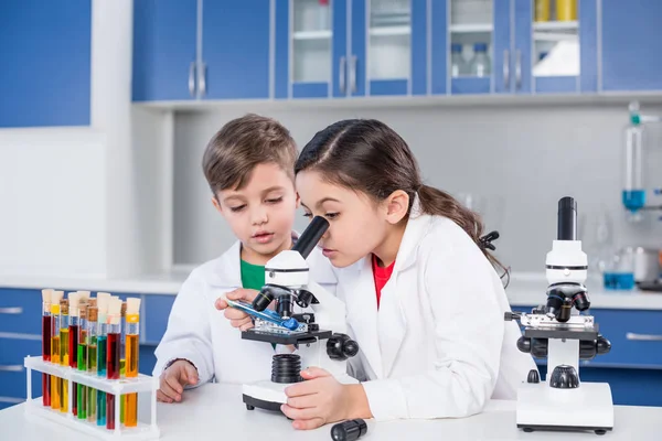 Niños usando microscopio - foto de stock