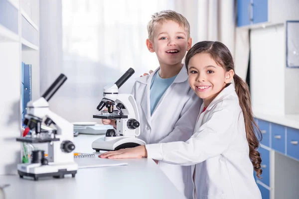 Niños usando microscopio - foto de stock