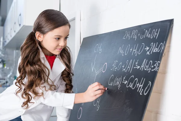 Niña escribiendo fórmula química - foto de stock