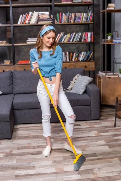 Young woman with broom — Stock Photo