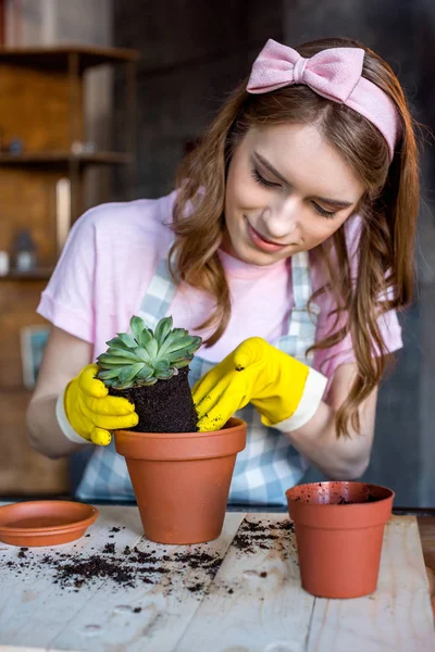 Frau setzt Pflanze in Blumentopf — Stockfoto