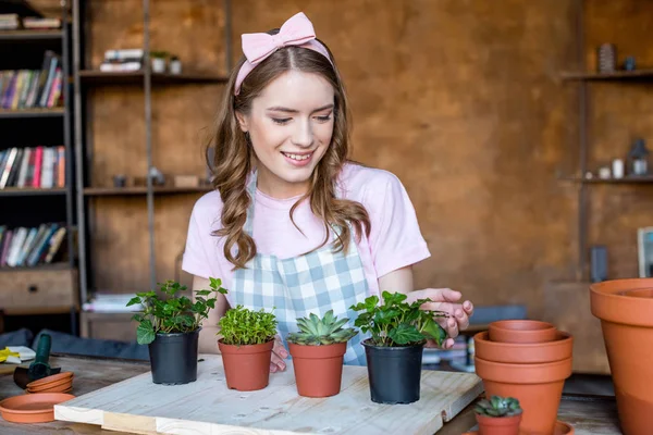 Femme avec des plantes dans des pots de fleurs — Photo de stock