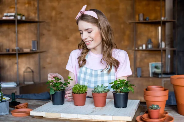 Donna con piante in vasi da fiori — Foto stock