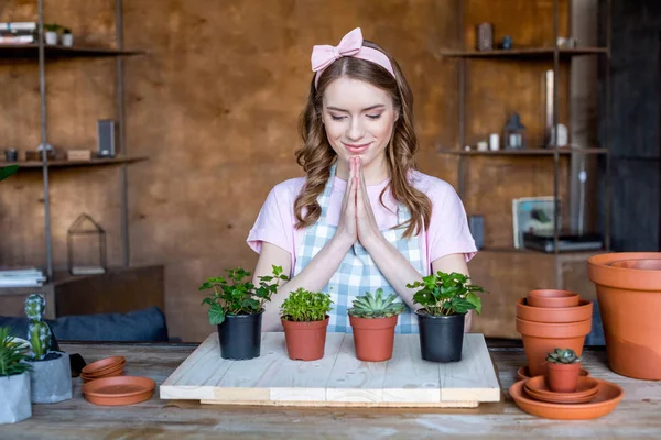 Femme avec des plantes dans des pots de fleurs — Photo de stock