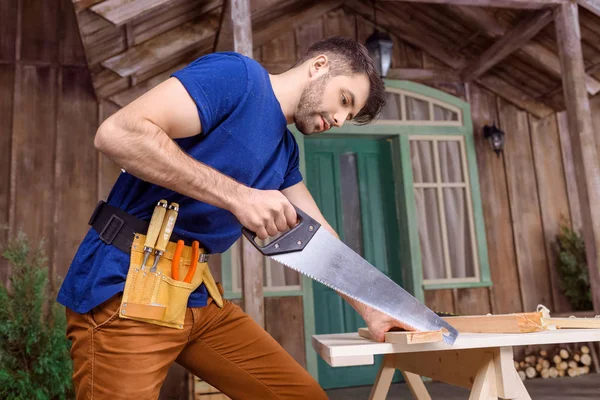 Carpenter sawing wood — Stock Photo