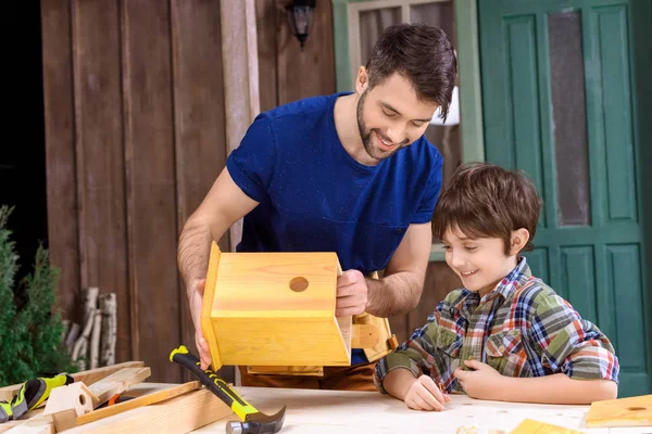 Padre e figlio che fanno la casa degli uccelli — Foto stock