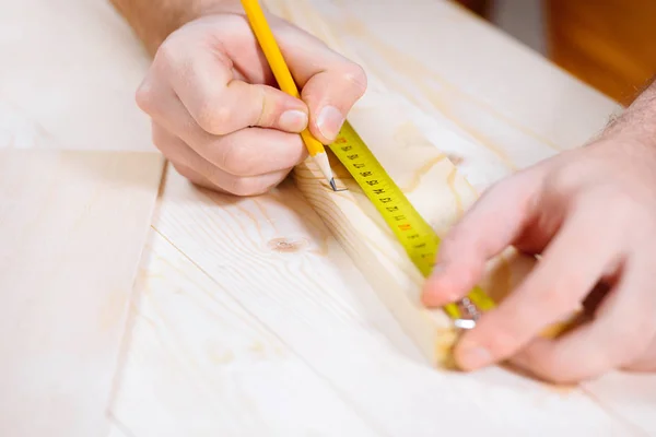 Carpintero trabajando con tablón de madera - foto de stock