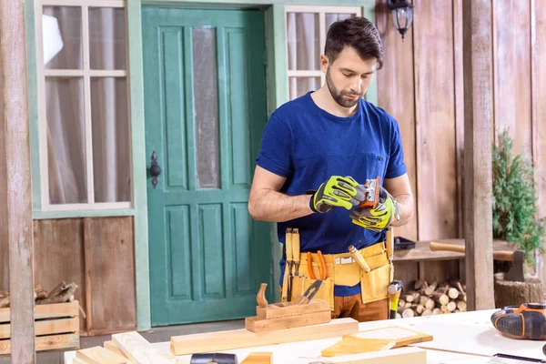 Carpintero trabajando con tablón de madera - foto de stock