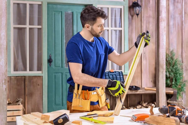 Carpintero trabajando con tablón de madera - foto de stock