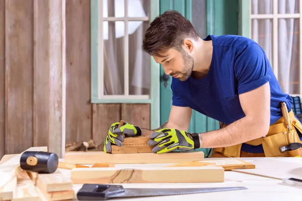 Carpintero trabajando con tablón de madera - foto de stock