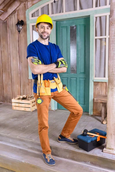 Carpenter with tools on porch — Stock Photo