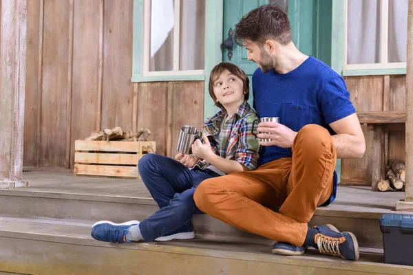 Uomo e ragazzo seduto sul portico — Foto stock