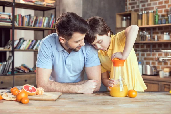 Father and son squeezing juice — Stock Photo
