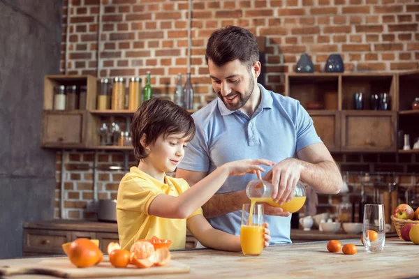 Father and son drinking juice — Stock Photo
