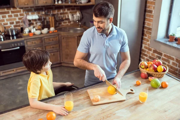 Padre e hijo exprimiendo jugo - foto de stock