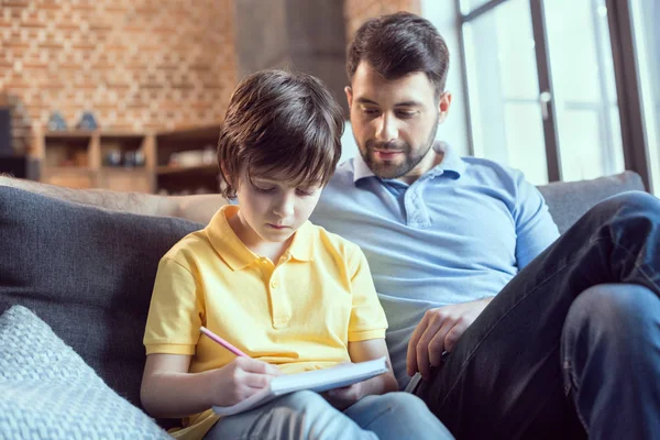 Pai ajudando filho fazendo lição de casa — Fotografia de Stock