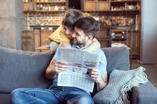 Padre e hijo leyendo el periódico - foto de stock
