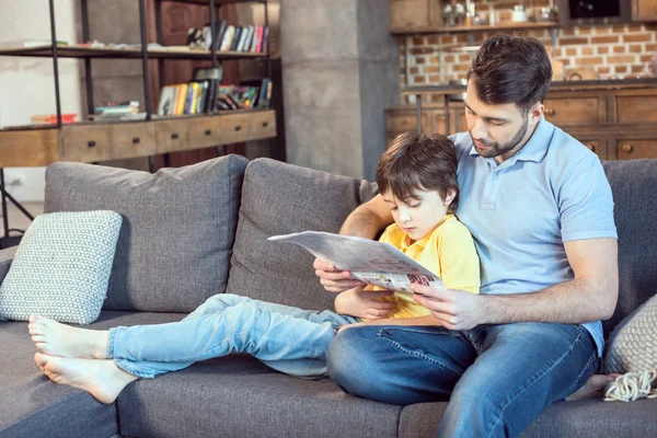 Pai e filho lendo jornal — Fotografia de Stock
