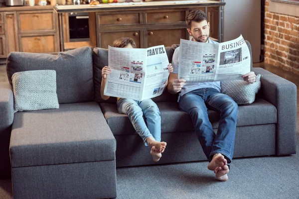 Padre e hijo leyendo periódicos - foto de stock