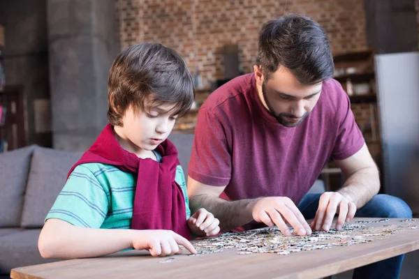Père et fils palyser avec des puzzles — Photo de stock