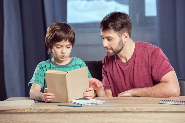 Padre aiuta il figlio a fare i compiti — Foto stock