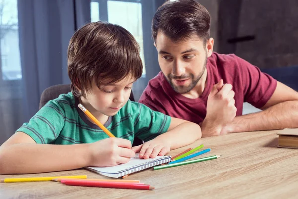 Pai ajudando filho fazendo lição de casa — Fotografia de Stock