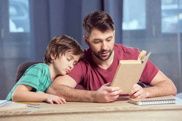 Père aidant son fils à faire ses devoirs — Photo de stock