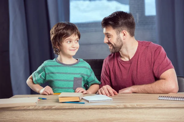 Padre ayudando a hijo haciendo la tarea - foto de stock