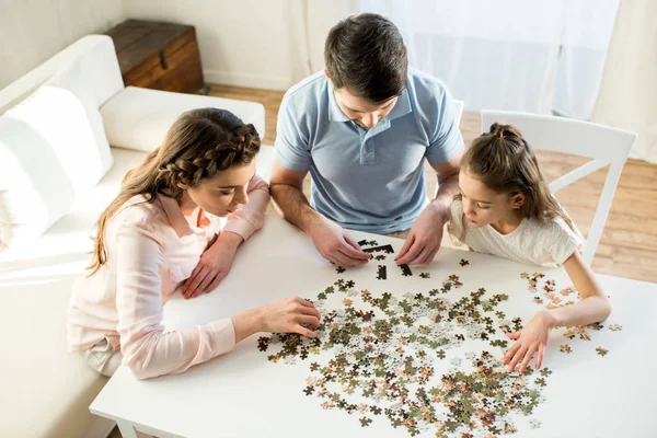 Familia jugando con rompecabezas - foto de stock