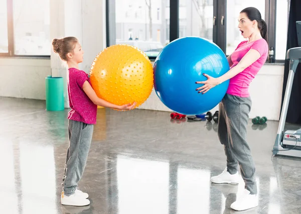 Madre e hija con pelotas de fitness - foto de stock