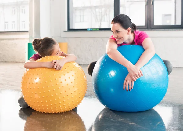 Madre e hija con pelotas de fitness - foto de stock