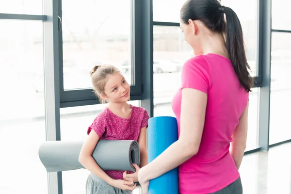 Mother and daughter with yoga mats — Stock Photo