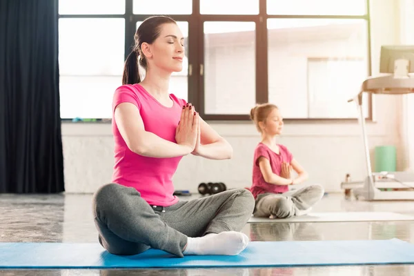 Mother and daughter in lotus pose — Stock Photo