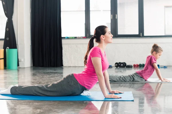 Madre e hija practicando yoga - foto de stock