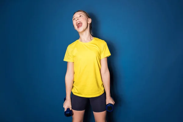 Preteen girl training with dumbbells — Stock Photo