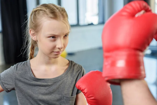 Preteen girl boxing with trainer. — Stock Photo